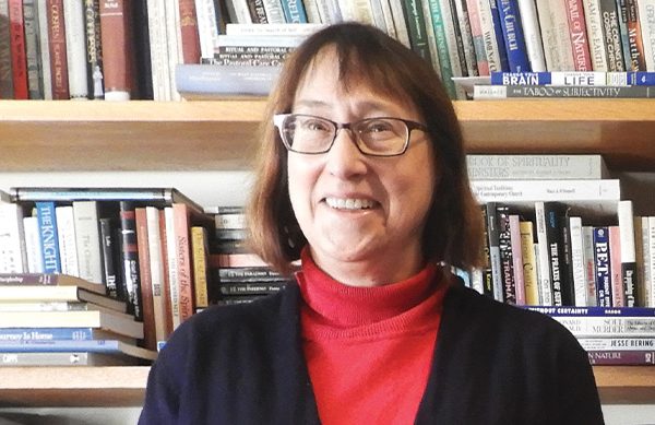 Dr. Kelcourse in front of a bookshelf in her office.