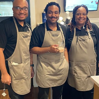 Former CTS student and staff member Eric Lesure (left) with staff baristas pause for a quick photo during the February 27th grand opening of The Avenue Coffeeshop and Café.