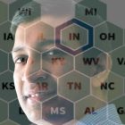 A man's face appears behind a semi-transparent table with letters.
